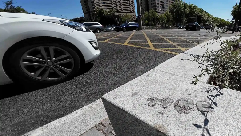 Image of a busy main avenue with cars, featuring the word 'TIME' made of ice that is melting over time.