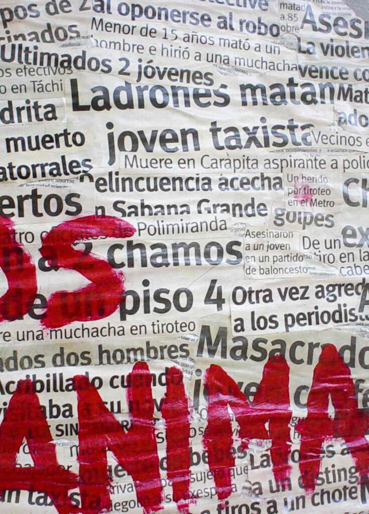 Image Zoom of the silhouette of the map of Venezuela pasted on a street wall, created with newspaper clippings that mention the murders and insecurity in Venezuela, with the words "not even the animals" written in red in the middle of the map.