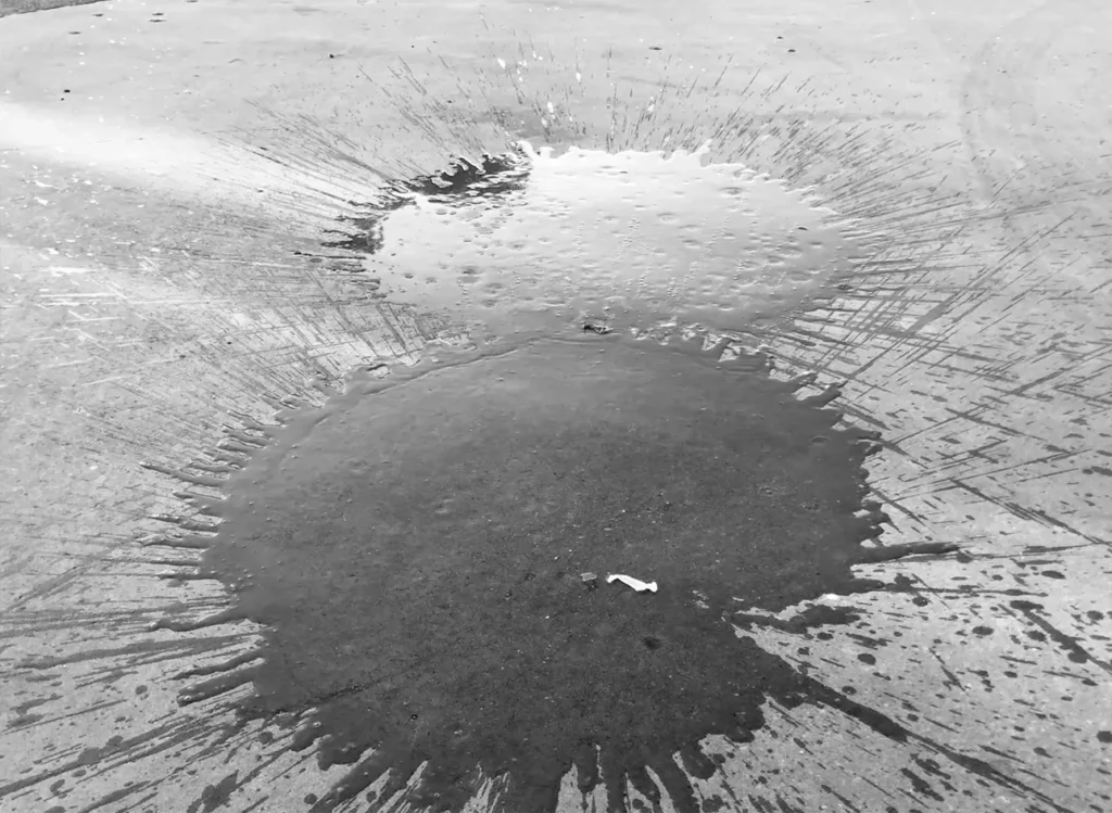 Two water puddles on the concrete ground formed by the impact of water balloons