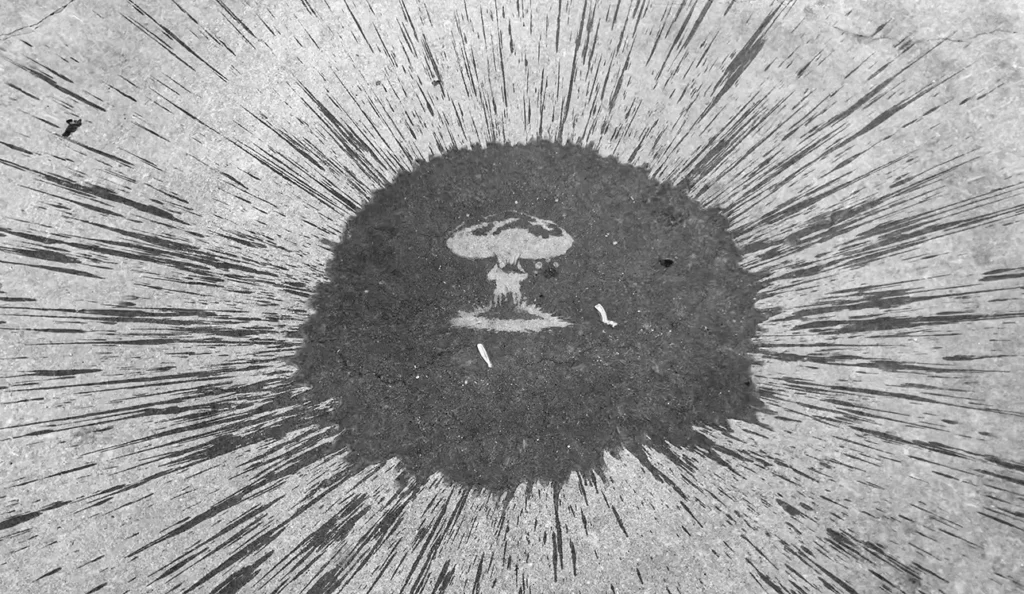 Water balloon bursting on the concrete ground, revealing the shape of a nuclear bomb explosion