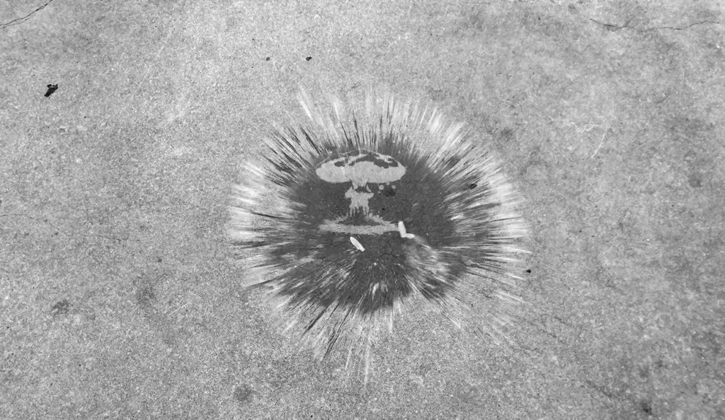Water balloon bursting on the concrete ground, revealing the shape of a nuclear bomb explosion